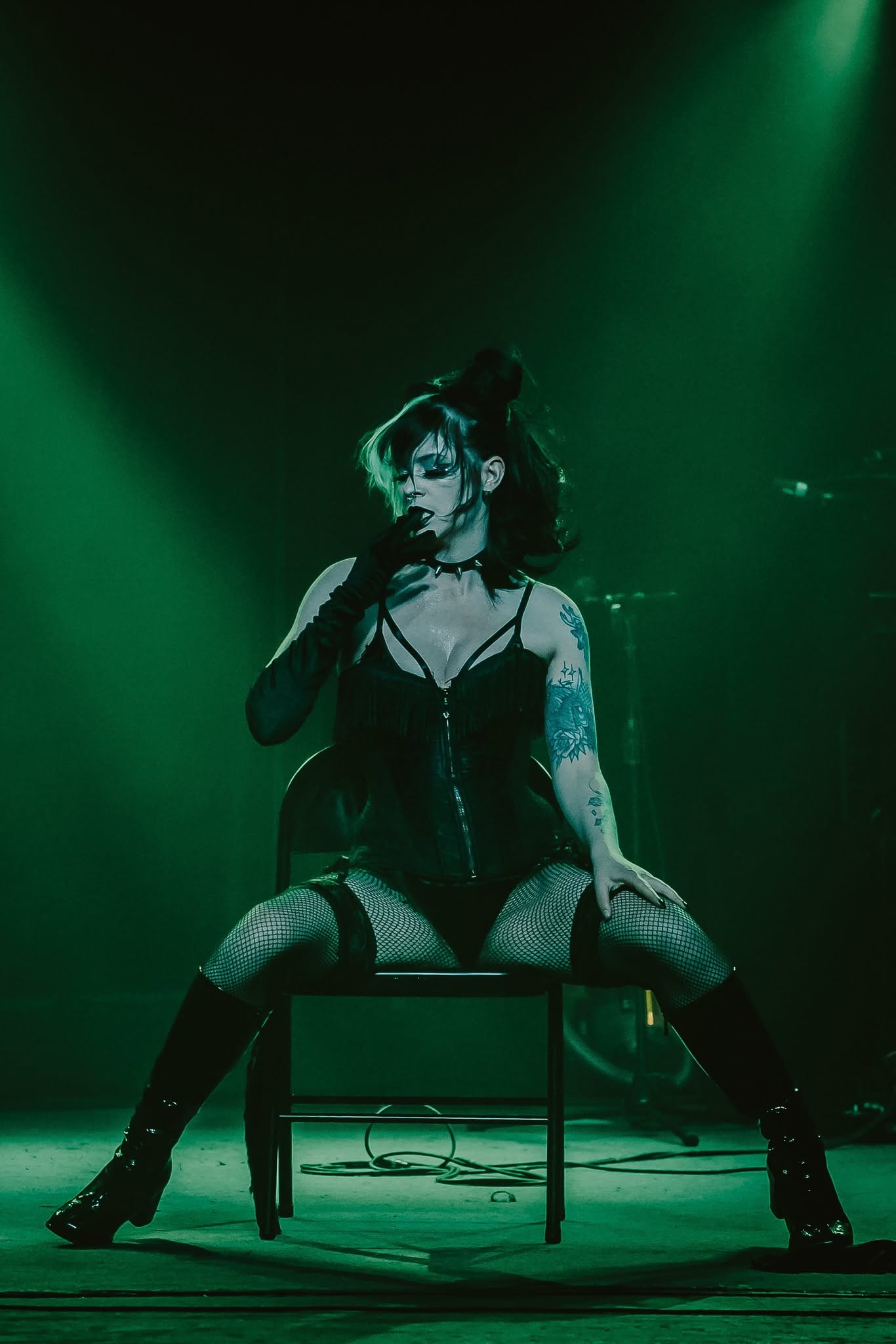 Performer under green light, mid-song