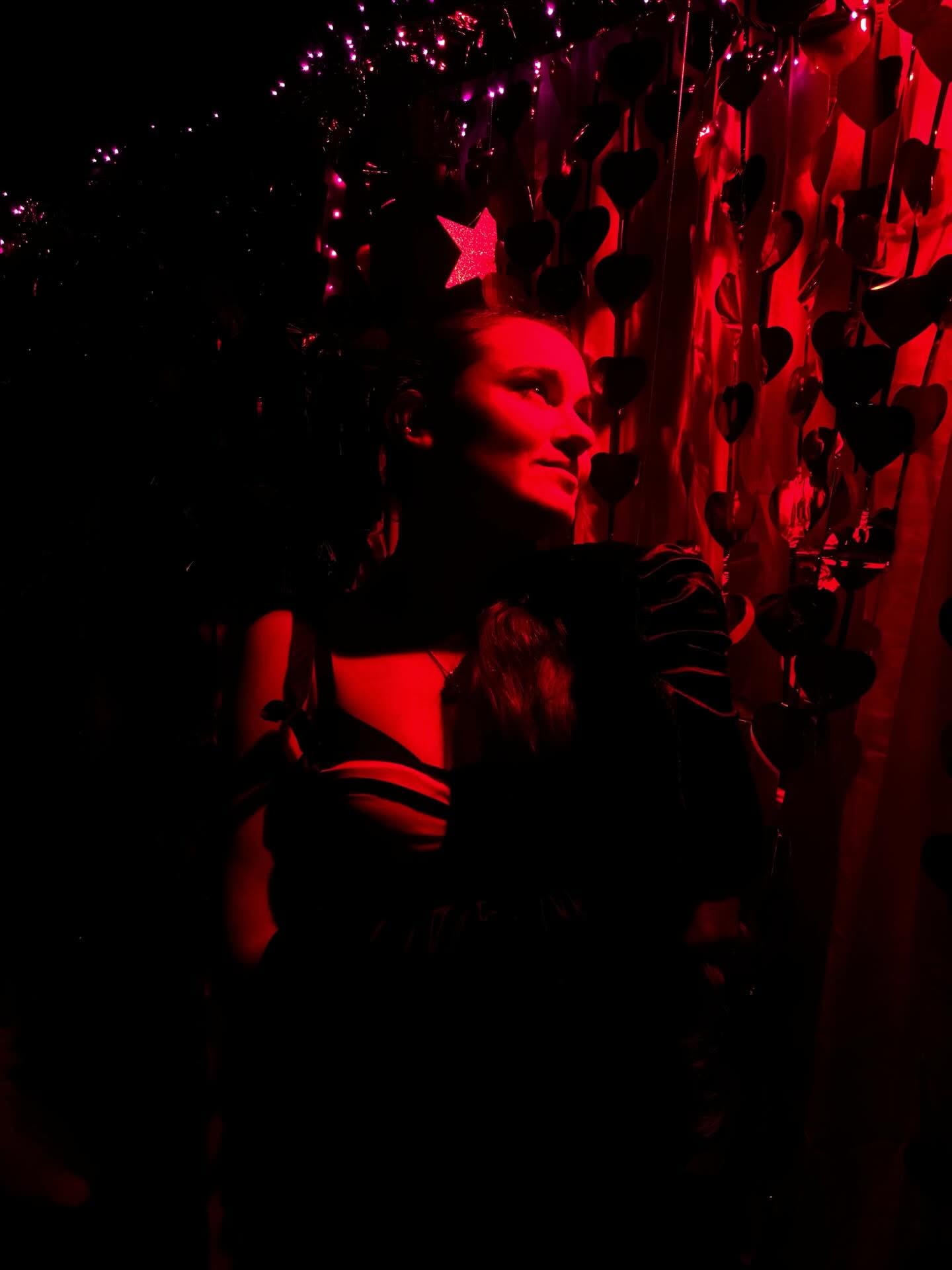 Performer in red light with a star headpiece